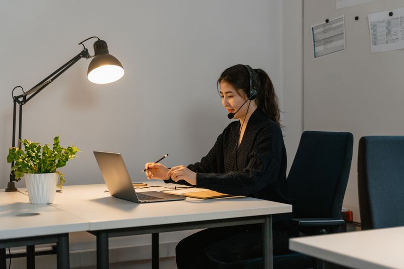 A headset-wearing professional handling a conversation. Stock photography.