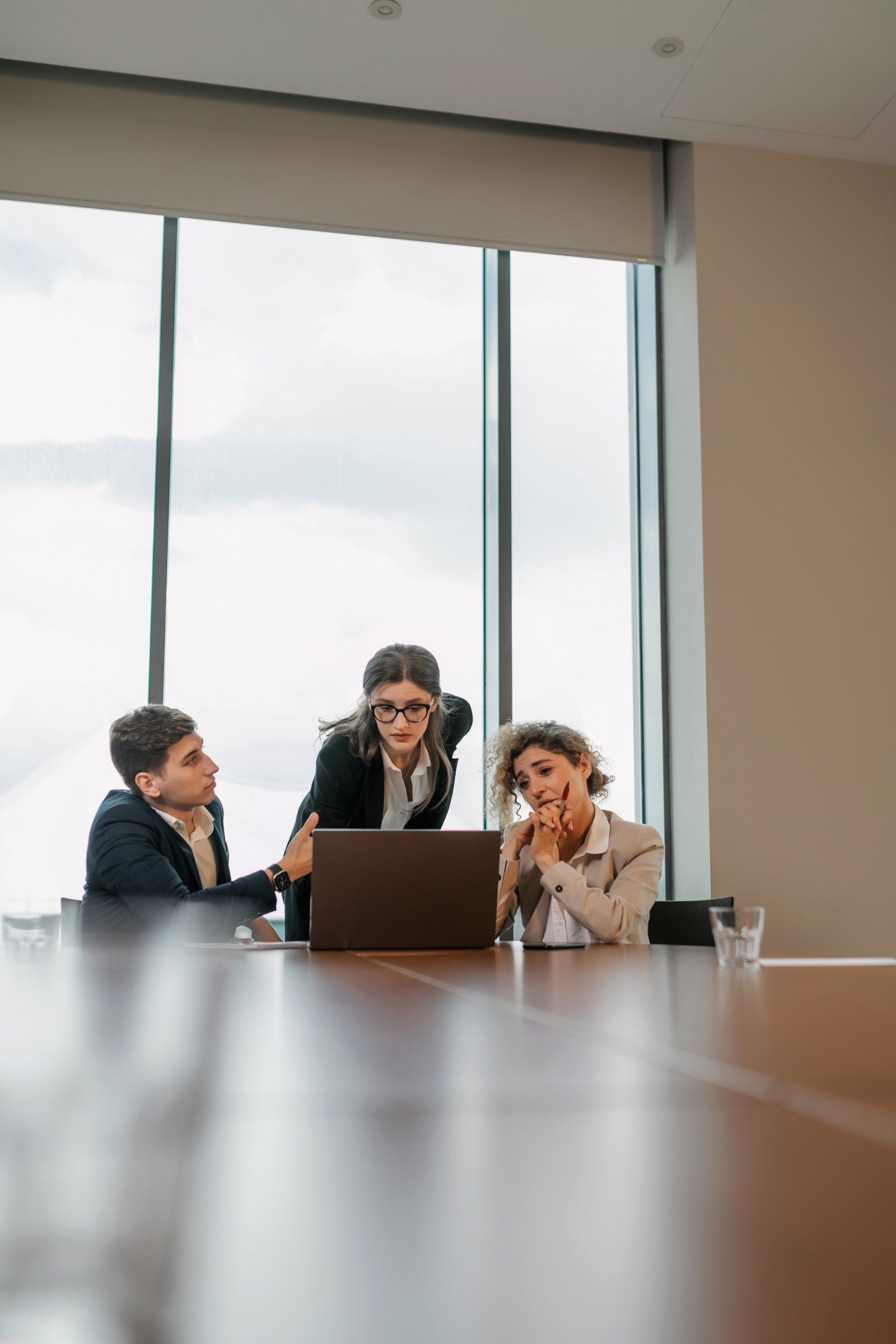 Colleagues reviewing work together on a laptop. Stock photography.